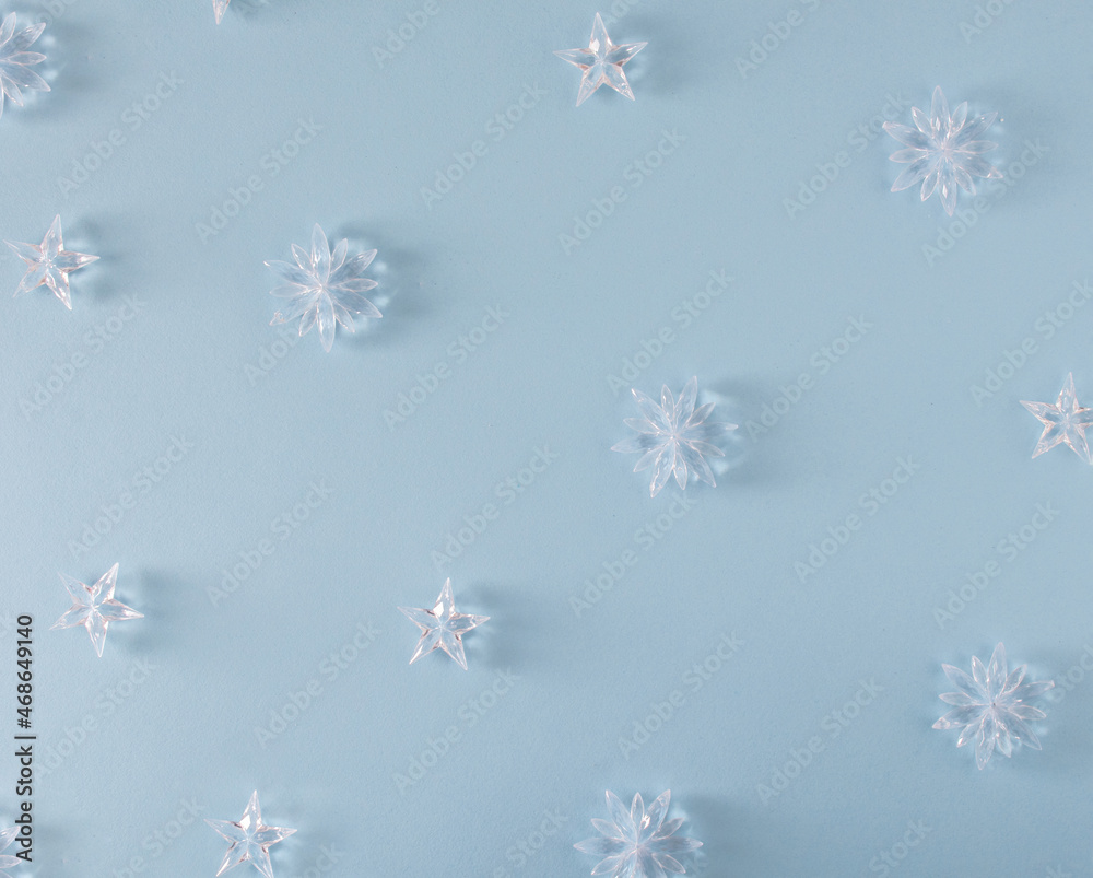 pattern made with frozen white snowflakes with shadows against pastel blue background. modern winter flat lay background.