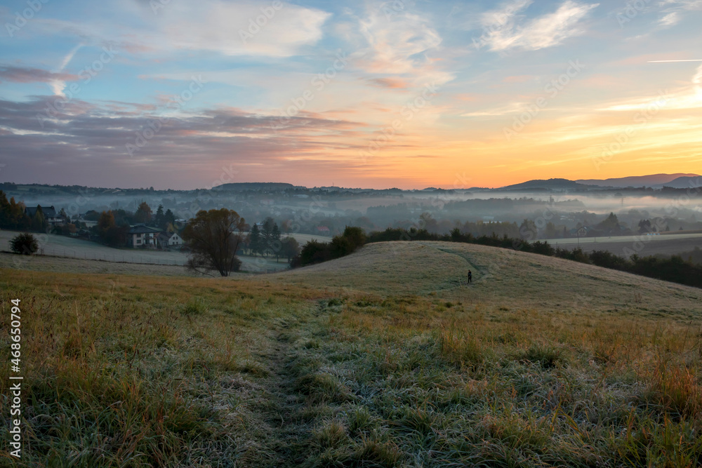 Misty sunrise on the meadow and the first frost