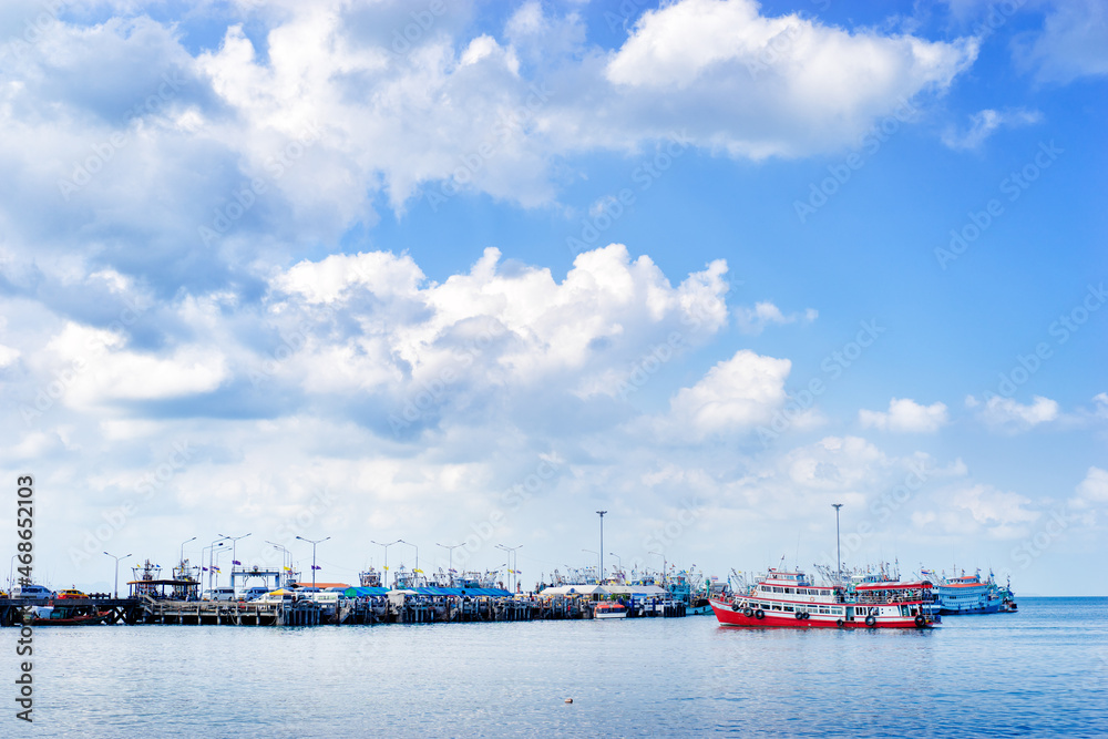 Fototapeta premium Ferry landing pier with fishing ship. Landscape with blue sea and sky.