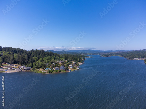 Aerial view. Picturesque landscape. Small town, a lot of greenery on the banks of a large river. Small houses, mountains can be seen in the distance. Housing issue, ecology. photo