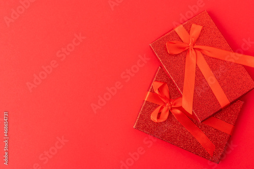 Two beautifully wrapped gifts on a red background. Birthday, Valentine's Day, wedding, wedding, New Years, Christmas, family holidays and celebrations. There is an empty space for an inscription.
