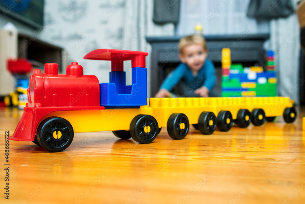 Child boy plays with block toys on floor in nursery at home or daycare. Educational toys for preschool and kindergarten child Child boy plays with block toys on floor in nursery at home or daycare. Educational toys for preschool and kindergarten child