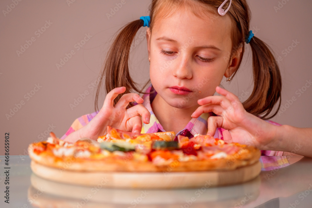 Portrait of young beautiful girl enjoys delicious slice of pizza. Horizontal image.