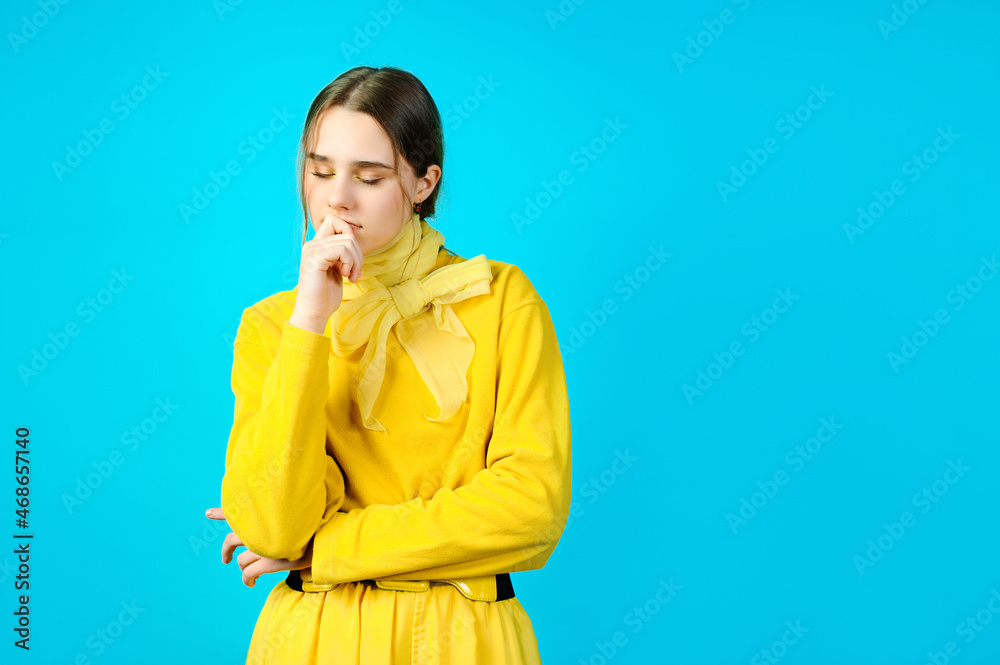portrait of a teenage girl in yellow clothes. blue background portrait of a teenage girl in yellow clothes. blue background