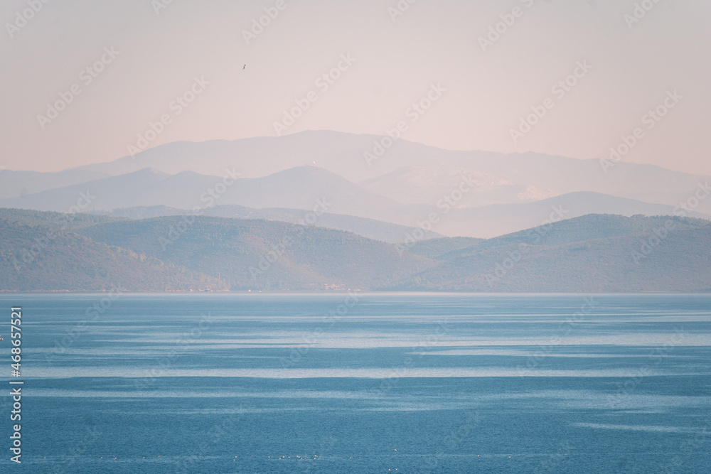 Natural background. Seascape with mountains at dawn.