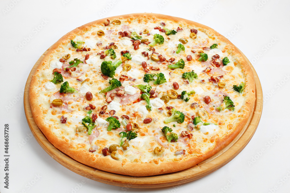 Pizza with ham, broccoli, beans and olives.. Italian kitchen and cooking concept. Chief with a pizza cutter cutting pizza to pieces at Neapolitan pizzeria. Pizza with ham, broccoli, beans and olives.. Italian kitchen and cooking concept. Chief with a pizza cutter cutting pizza to pieces at Neapolitan pizzeria.