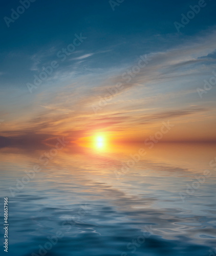 Sunset in the sky with bright sun and sea waves. © Sviatoslav Khomiakov