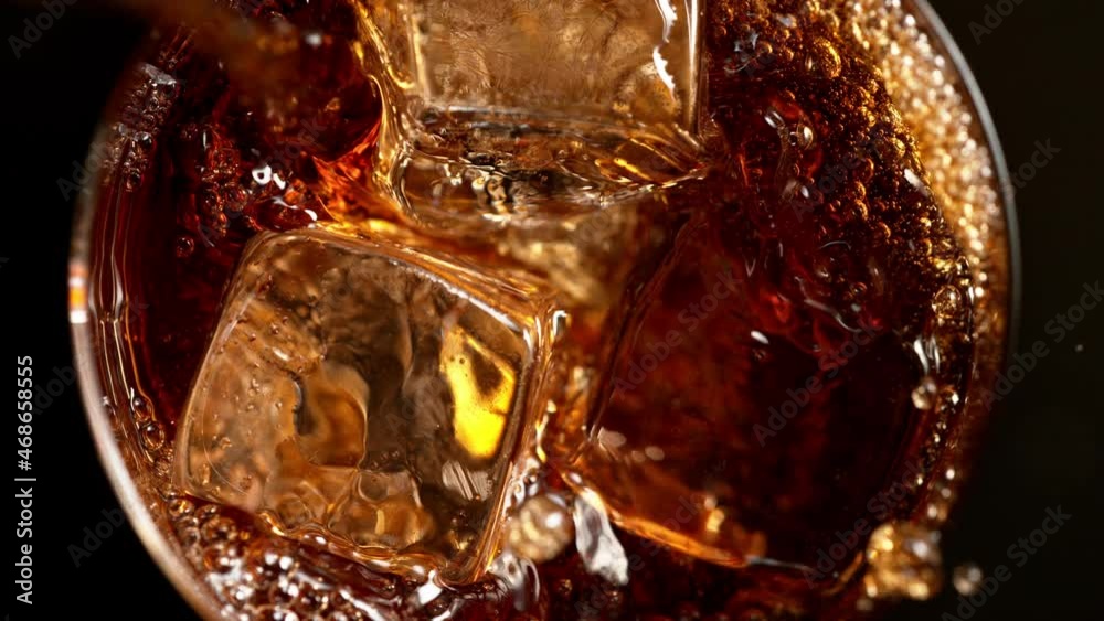 Super slow motion of pouring whiskey into glass, top view shot. Filmed on high speed cinema camera, 1000fps Super slow motion of pouring whiskey into glass, top view shot. Filmed on high speed cinema camera, 1000fps