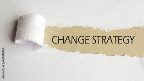 change strategy. words. text on gray paper on torn paper background.