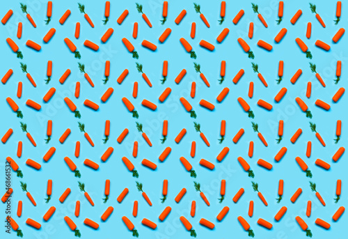 Pattern of carrots on blue background. Design for Easter or wrapping paper. Creative copy space