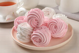 Plate with delicious pink zephyrs on white table