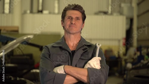 Car service, repair, maintenance and people concept. Waist up portrait view of the auto mechanic man or smith with wrench at workshop
