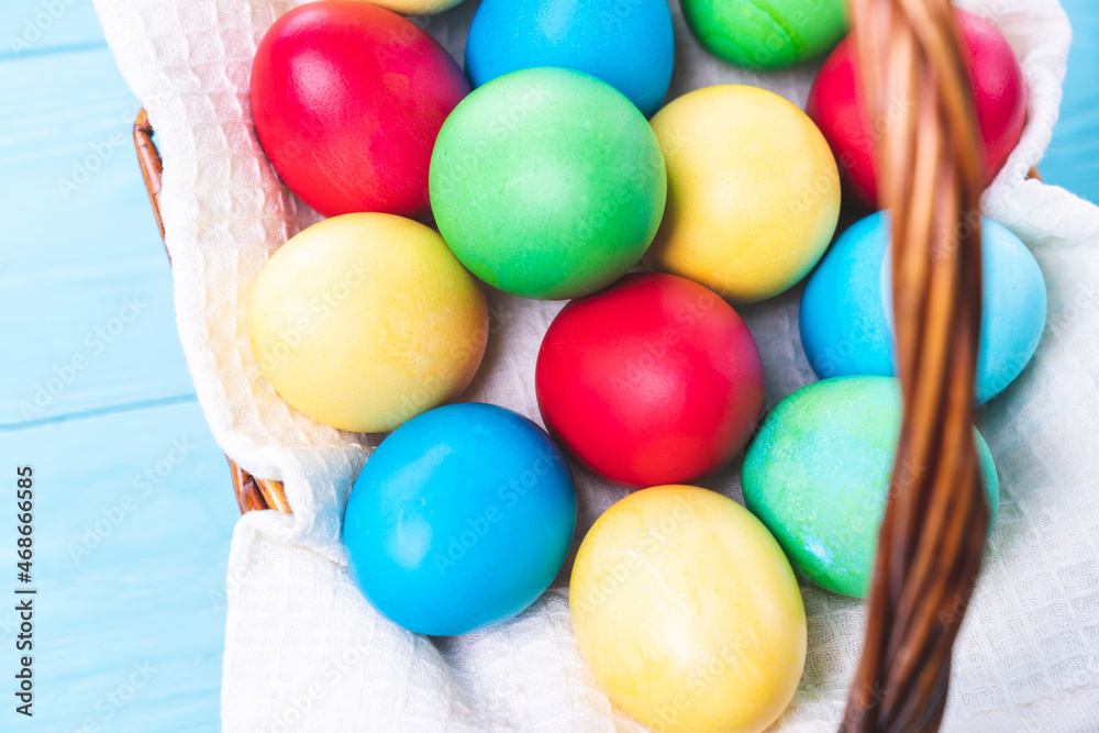 basket with colorful Easter eggs on a blue wooden background, selective focus, tinted image basket with colorful Easter eggs on a blue wooden background, selective focus, tinted image