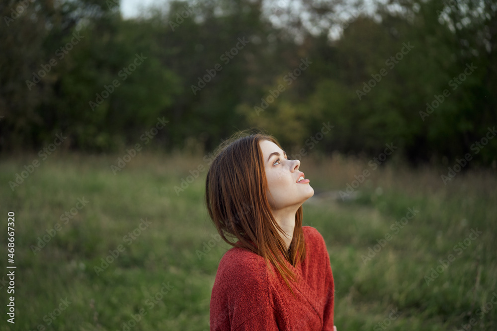 woman in a red sweater outdoors in the field nature rest woman in a red sweater outdoors in the field nature rest