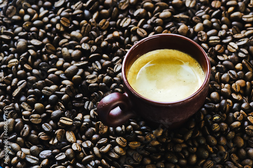 Coffee cup with free space for text on roasted coffee beans close up