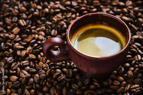 Coffee cup with free space for text on roasted coffee beans close up