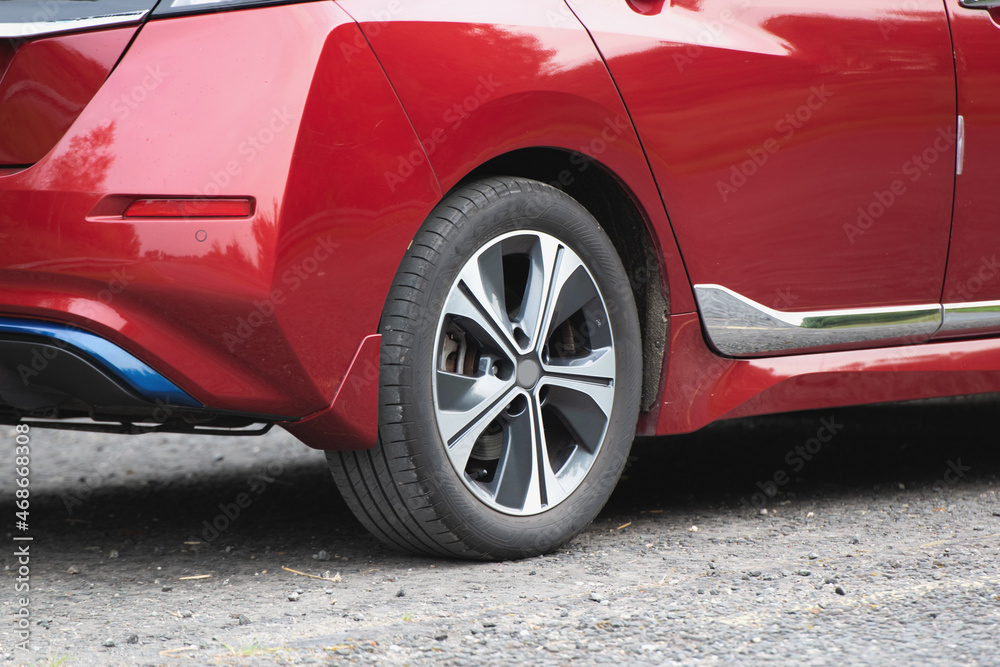 Red car. Car wheels close up on a background of asphalt.