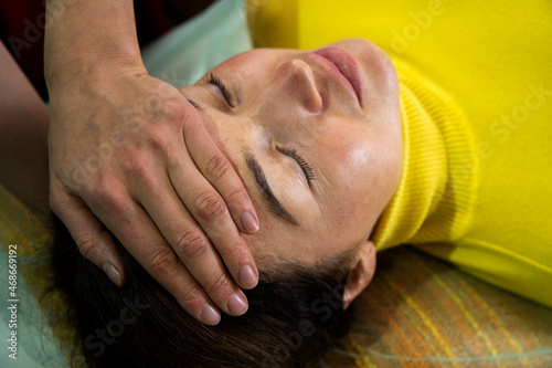 A young woman practices the technique of kinesiology. Chiropractic treatment, Back pain relief. Physiotherapy for female patient, Kinesiology.