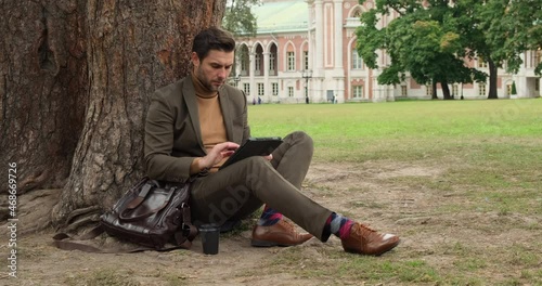 Harvard Business School. startup Businessman working in tablet to find solution. Student sit outside on Quad lawn of University of Illinois college campus in Urbana Champaign. University Campus photo