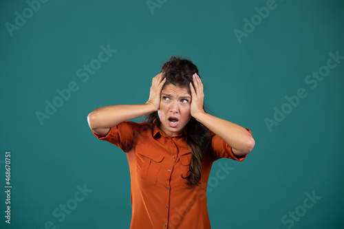 Frustrated woman with hands on head in studio