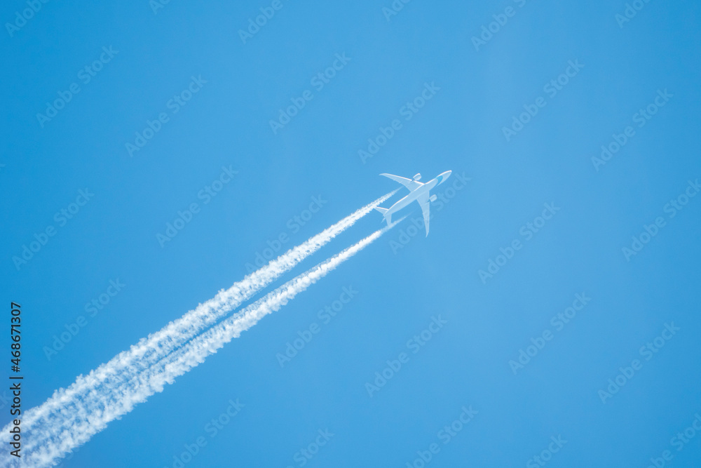 Ein Flugzeug mit Kondensstreifen vor strahlend blauem Himmel Ein Flugzeug mit Kondensstreifen vor strahlend blauem Himmel