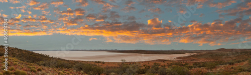 Panorama of Australia’s third largest salt lake, Lake Gairdner. The glistening, white, salt, surface is surrounded by the red foothills of the Gawler Ranges. photo