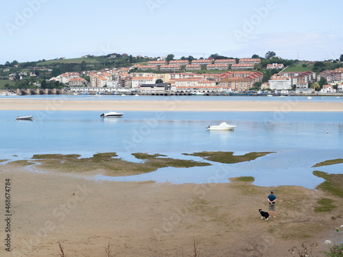 Paisaje de San Vicente de la Barquera con barcas en el agua, y el pueblo al fondo en Cantabria, España, en el verano de 2020.
