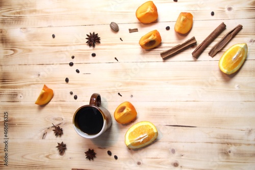 Cup of fruit coffee with spices on wooden table
