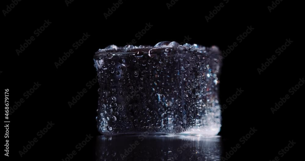 Closeup ice cubes rotating on dark background. Closeup ice cubes rotating on dark background.