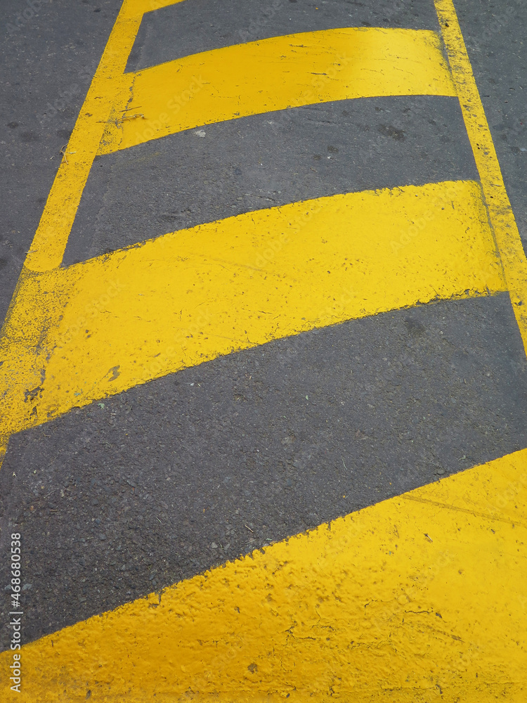 Fototapeta premium Yellow striped road markings on black asphalt