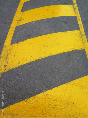 Yellow striped road markings on black asphalt © Aroastock