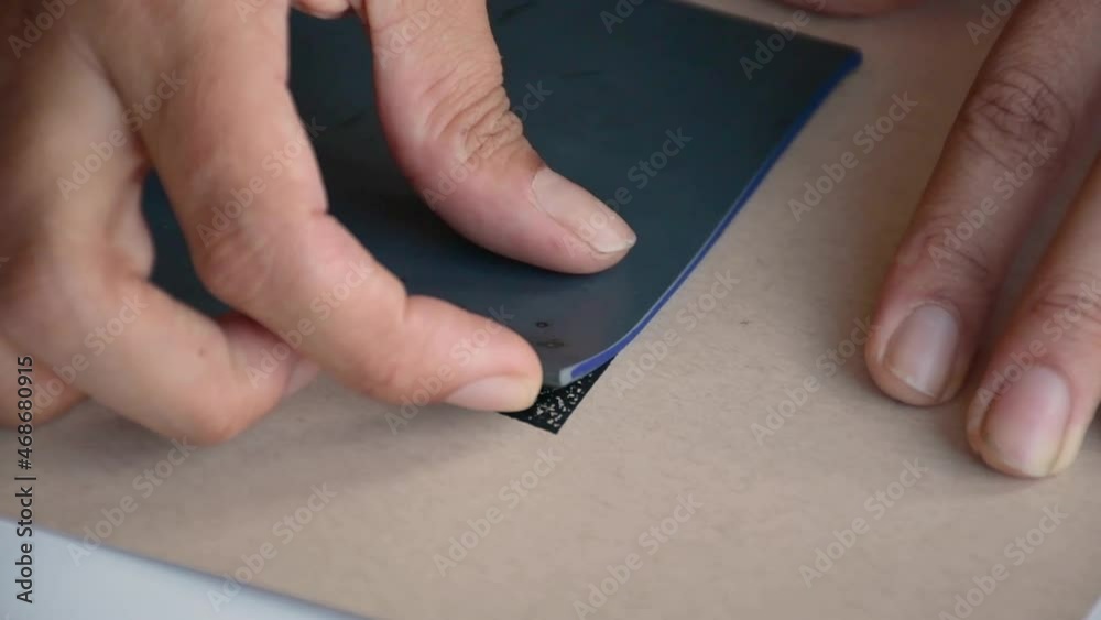 A closeup shot of a person's hands doing lino block printing