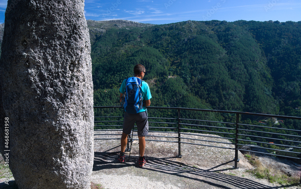 Φωτογραφία Homem parado no meio de uma caminhada de um trilho de montanha para apreciar a v