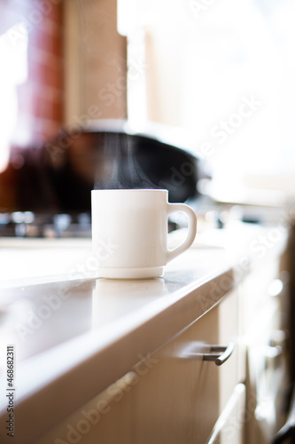 White cylinder cup on kitchen table with real natural daylight, mock-up ready coffee mug