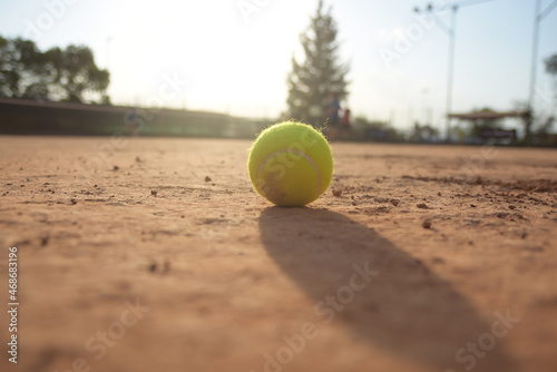 tennis ball on brick court with sunset background