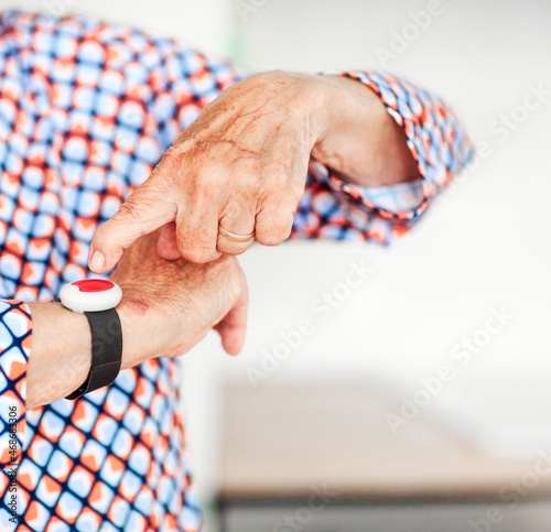 Senior woman hands with emergency alarm button, closeup