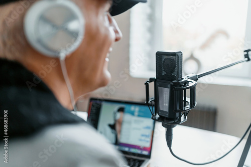An adult man speaks into the microphone. Workplace in the recording studio. The blogger is blogging communication with clients. The radio presenter transmits the news in the morning.