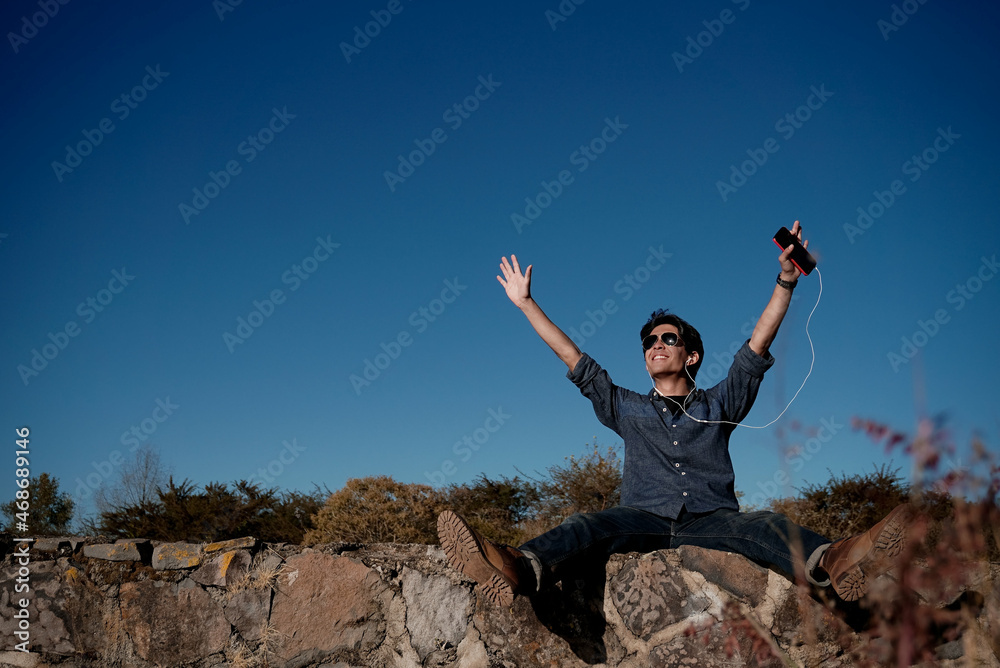 Joven feliz escuchando música al atardecer Joven feliz escuchando música al atardecer