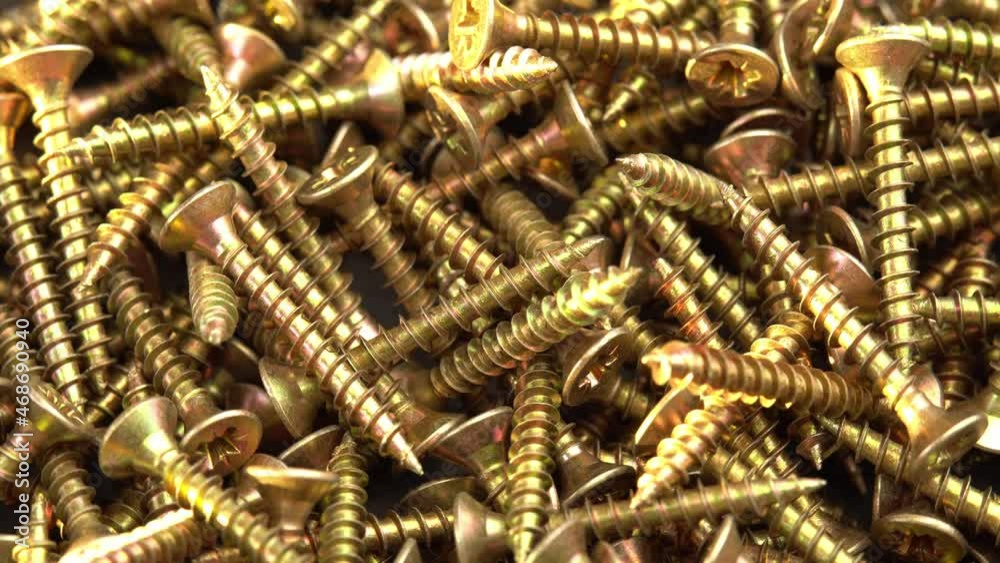 Golden screws or cross head screws rotate like background, construction supplies self-tapping screws or bolts Golden screws or cross head screws rotate like background, construction supplies self-tapping screws or bolts