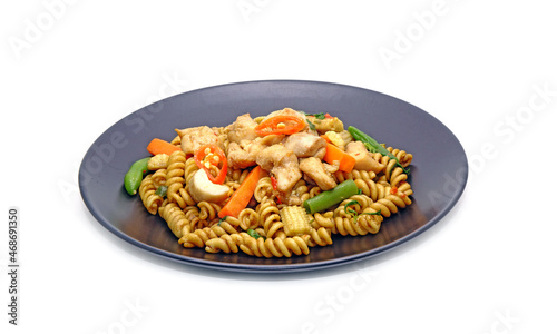 Thai Spicy Fusilli with chicken and herbs isolated on white background. Drunken Fusilli with chicken, Thai style pasta. Fusion food, Thai - Italian cuisine