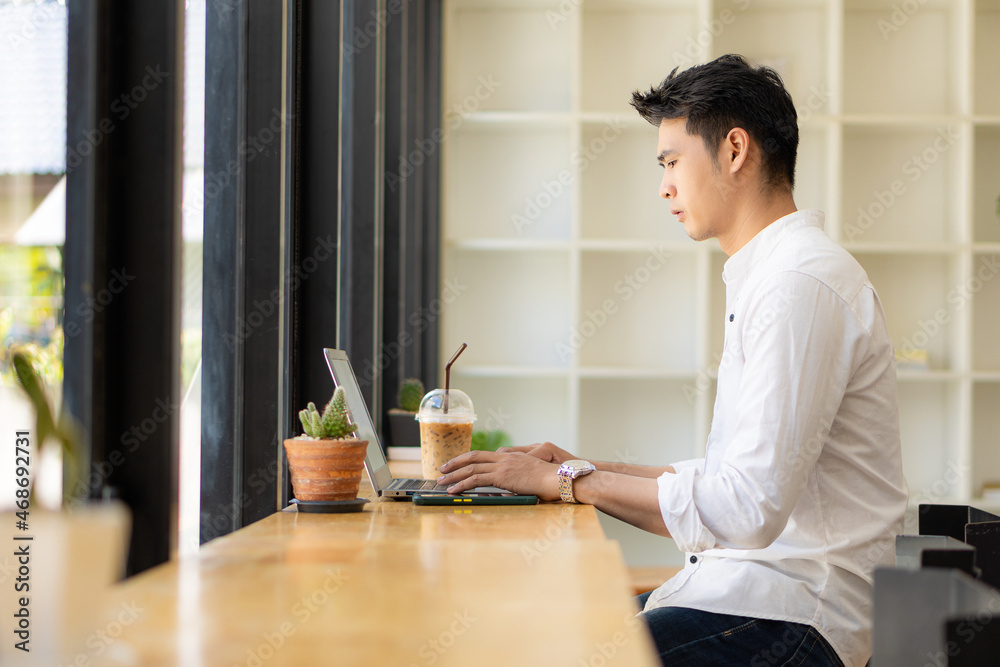 Young Asian men, future students for self or personal learning ideas. Online students at coffee shops with books and laptops. Young Asian men, future students for self or personal learning ideas. Online students at coffee shops with books and laptops.