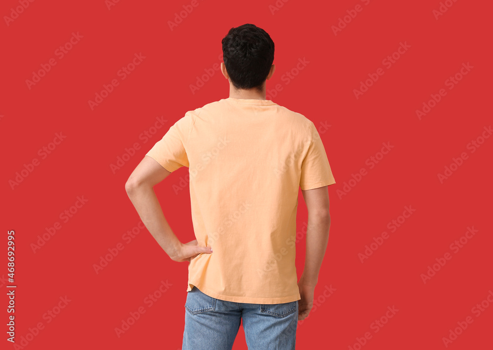 Handsome young man in stylish t-shirt on color background, back view Handsome young man in stylish t-shirt on color background, back view