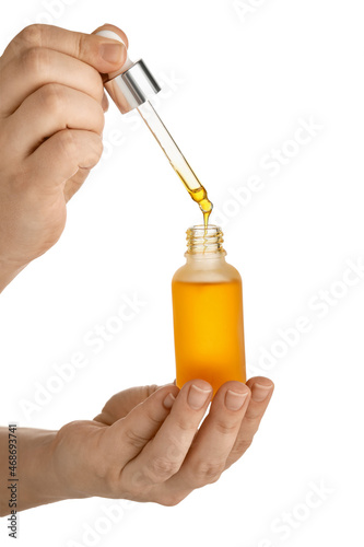 Woman holding bottle of essential oil against background, closeup