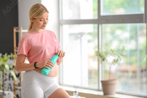 Young pregnant woman openin...