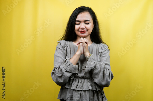 Beautiful young woman praying isolated