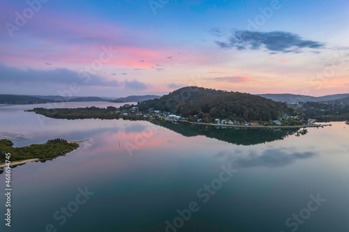 Soft and peaceful sunrise aerial waterscape with clouds and reflections