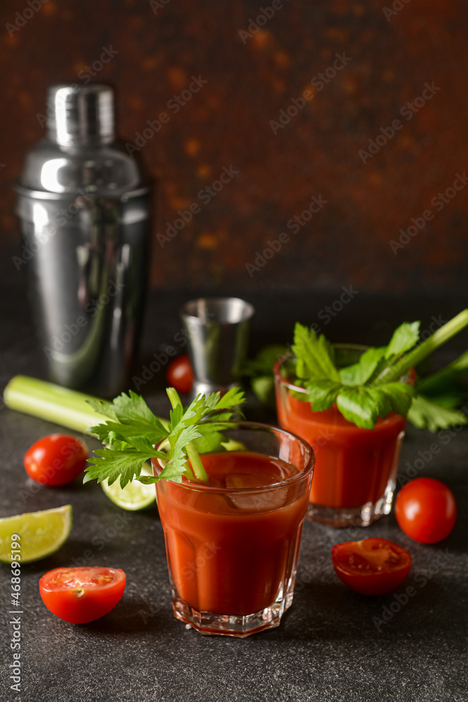 Glasses of bloody mary with celery, lime and tomatoes on table Glasses of bloody mary with celery, lime and tomatoes on table