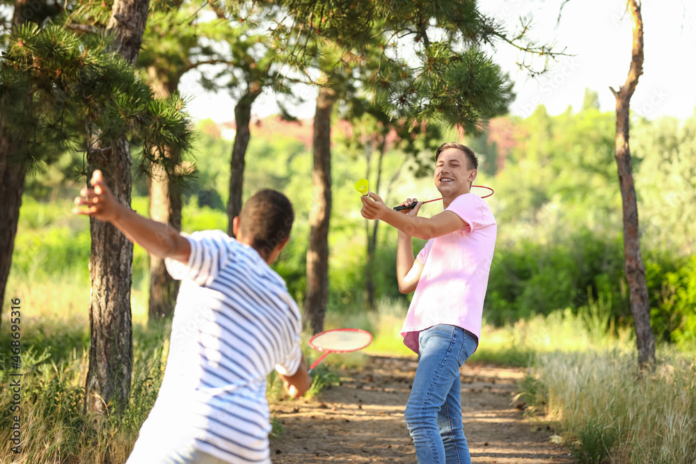 Young men playing badminton outdoors Young men playing badminton outdoors