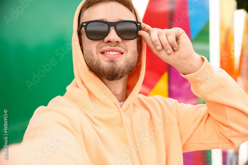 Young guy in stylish hoodie taking selfie outdoors © Pixel-Shot