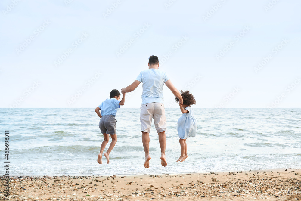 Little children with father on sea beach